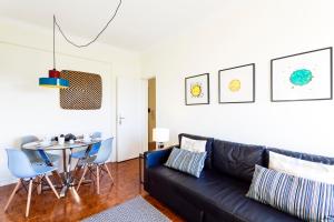salon z czarną skórzaną kanapą i stołem w obiekcie WHome | Anjos Stylish Apartment #6 w Lizbonie