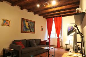 a living room with a couch and red curtains at FEEL - Arco Antico in Bergamo