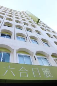un edificio con una señal delante de él en Sunnyside Hotel en Kaohsiung
