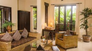 a living room with a couch and a table at Lily Lane Villas in Ubud