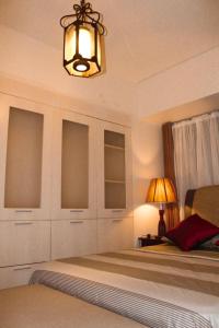 - une chambre avec un lit et un lustre dans l'établissement One- Bedroom Avida Cebu Tower 1 IT Park, à Cebu