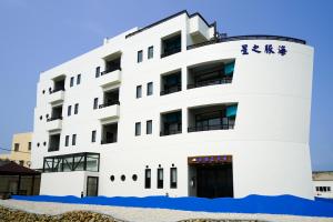 a white building with chinese writing on it at Captain Ou Homestay in Huxi