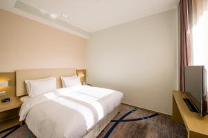 a bedroom with a white bed and a television at Holiday Inn Express Chengde Downtown, an IHG Hotel in Chengde