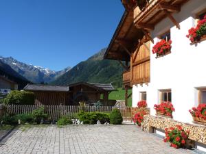 a courtyard of a house with flowers on the facade at Conny's Ferienwohnungen in Gschnitz