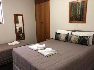 a hotel room with a bed and a mirror at The Tahitian in Coffs Harbour