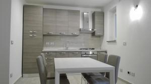 a kitchen with a table and chairs and a sink at Rocca sul Lago in Castro