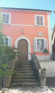 una casa rosa con escaleras que conducen a una puerta en Lo Sghimbescio, en Marradi