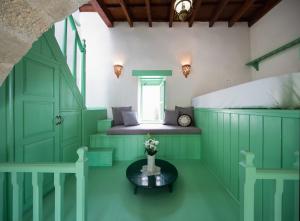 a room with green doors and a bed and a table at Hartso - Traditional loft, renovated former forge in Gennadi in Gennadi