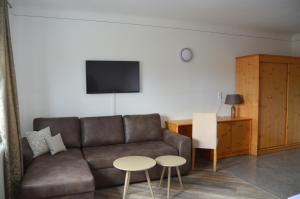 ein Wohnzimmer mit einem Sofa und 2 Tischen in der Unterkunft Pension zum Strell in Hollabrunn