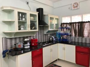 eine Küche mit weißen und roten Schränken und einem Herd in der Unterkunft EN Jays Residency (Service Apartments) in Kottayam