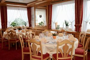 ein Esszimmer mit Tischen, Stühlen und Fenstern in der Unterkunft Gasthof Pfauen in Oberkirch