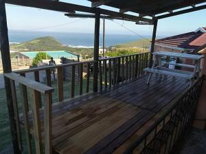 a wooden deck with a view of the ocean at Hillside View Guesthouse in Coffee Bay