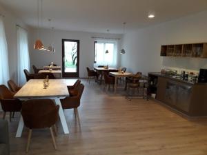 a dining room with tables and chairs and a kitchen at Garni Unterspeiser in Terlano