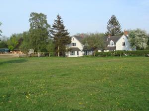 a large field of grass with two white houses at Alton Brook House in Combridge