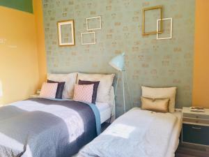 a bedroom with two beds and a nightstand with a lamp at STUDIO 18 in Sopron