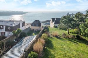 a house on a hill next to the ocean at Residence Le Phare de Trescadec - maeva Home in Audierne