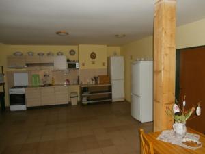 a large kitchen with white appliances and a table at Penzion Zemanův Dvůr in Božanov
