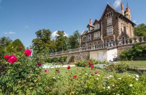Parentignat的住宿－Manoir des Rêves Sauvages，一座古城堡,前面有鲜花