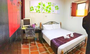 a bedroom with a bed and a desk with a computer at LuoFunJyu in Jincheng +43 photos