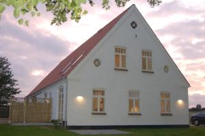 a white house with a gambrel roof at Fjordvejen Apartments in Gråsten