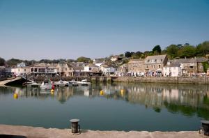 a river with boats in a town with houses at The White House in Padstow