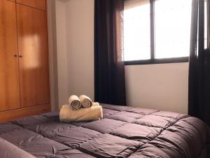 a bedroom with a bed with towels and a window at Tesorillo in Almuñécar