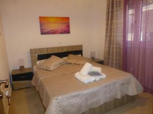 ein Schlafzimmer mit einem Bett mit Handtüchern darauf in der Unterkunft Pavloudis Apartments in Psakoudia