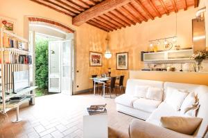 uma sala de estar com um sofá branco e uma mesa em Apartment Guinigi with Private Courtyard em Lucca