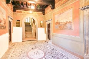 um corredor com uma pintura na parede e um tapete no chão em Apartment Guinigi with Private Courtyard em Lucca