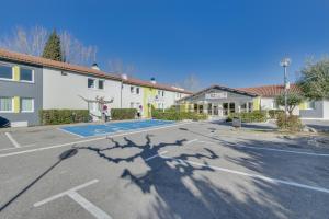 um parque de estacionamento vazio em frente a um edifício em B&B HOTEL FREJUS Puget-sur-Argens em Fréjus