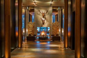 a lobby with couches and a fireplace and a deer head on the wall at The Chedi Andermatt in Andermatt