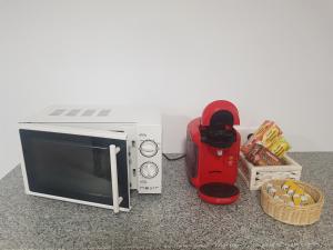a microwave on a counter next to a blender and snacks at Albergue Buen Camino Tui in Tui