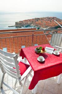 una mesa roja y sillas con vistas a la ciudad en Apartments Superb View, en Dubrovnik