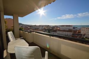 a balcony with a chair and a view of a city at Luxurious two-bedroom in Cannes