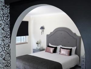 a bedroom with a large bed with an archway at Villa Moments - Guest House in Portimão