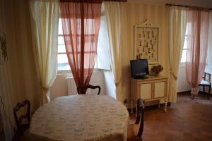 a bedroom with a table and a tv and windows at Palazzo Tucci Apartments in Lucca