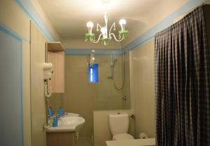a bathroom with a sink toilet and a chandelier at Palazzo Tucci Apartments in Lucca +18 photos