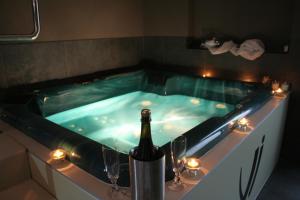 a hot tub with a bottle of wine and wine glasses at Wellness Villa Istriana in Umag