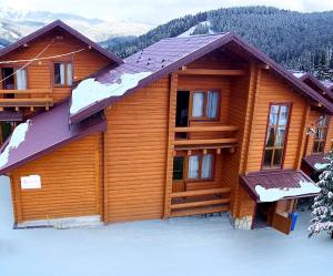 a log cabin in the snow with snow at Hotel Fiesta in Bukovel