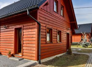 a red cabin with a black roof at Domki w Istebnej in Istebna