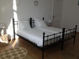 1 cama con sábanas blancas y almohadas en una habitación en Les Gîtes Du Pays De Charleroi en Charleroi