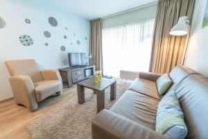 a living room with a couch and a chair at De Pelikaan Texel Appartementen in De Koog