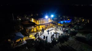 a group of people standing outside of a building at night at Terra dei Sogni in Torre Lapillo +179 photos