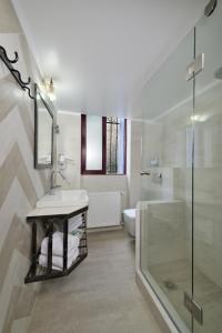 a bathroom with a sink, toilet and bathtub at Dryades & Orion Hotel in Athens