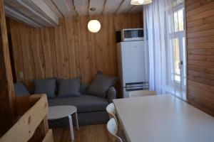 ein Wohnzimmer mit einem Sofa und einem Tisch in der Unterkunft Guest House Ziedkalni in Dūmele