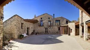 un gran edificio de piedra con un banco en un patio en Conjunt Rural Cal Soldat, en Collmorter