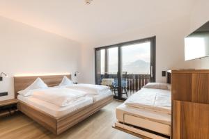 dwa łóżka w sypialni z balkonem w obiekcie Hotel Salgart w Meranie +34 zdjęcia