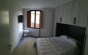 een slaapkamer met een bed, een raam en een televisie bij Alfredo's House in Siena