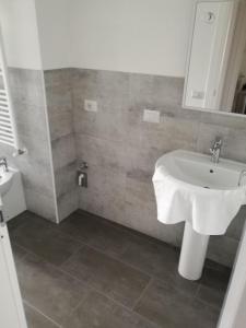 bagno con lavandino bianco e specchio di Alfredo's House a Siena