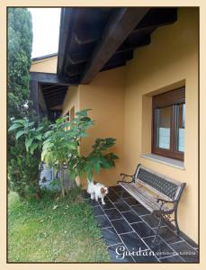 a cat sitting next to a bench in front of a house at Apartamentos Guidan in Ribadeo